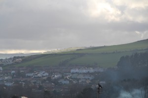 Distant hills picked out by the effects of sunlight, whilst a sea mist rolls inn along the valley